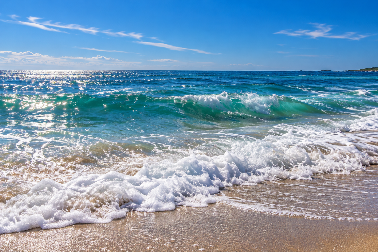 Ocean blue waves and white sea foam rolling onto a sandy beach — illustrative coastal scenery